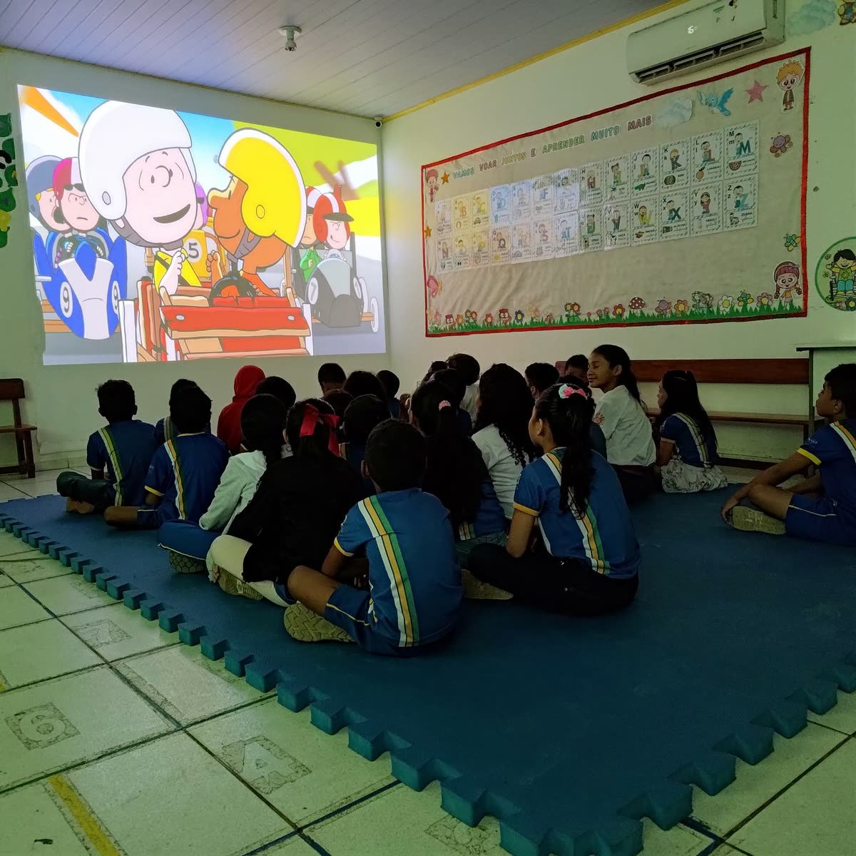 Crianças sorriem segurando uma faixa da sala de projeção